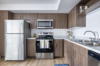 A modern kitchen with a white refrigerator, stove, and oven.